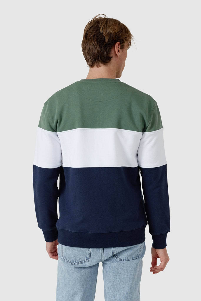 Back of model wearing crew neck sweater with a olive top panel, white middle panel and navy bottom panel