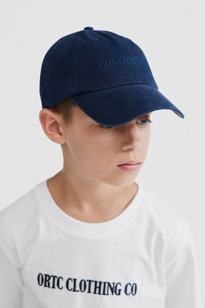 Child wearing navy baseball cap with navy embroidered ortc clothing co