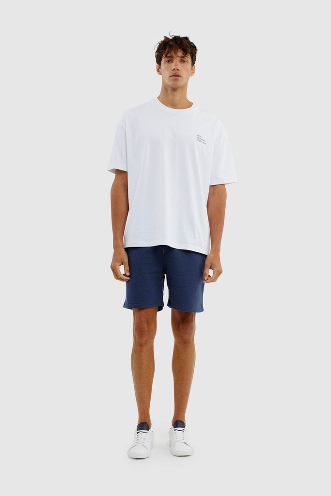 Full length of model wearing white boxy tshirt, navy lounge shorts and sneakers